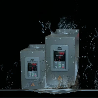 variador-industrial-v910-proteccion-ip54-resistente-agua Variadores de frecuencia serie V910 recibiendo salpicaduras de agua, demostrando su alto grado de protección IP54 para ambientes húmedos.